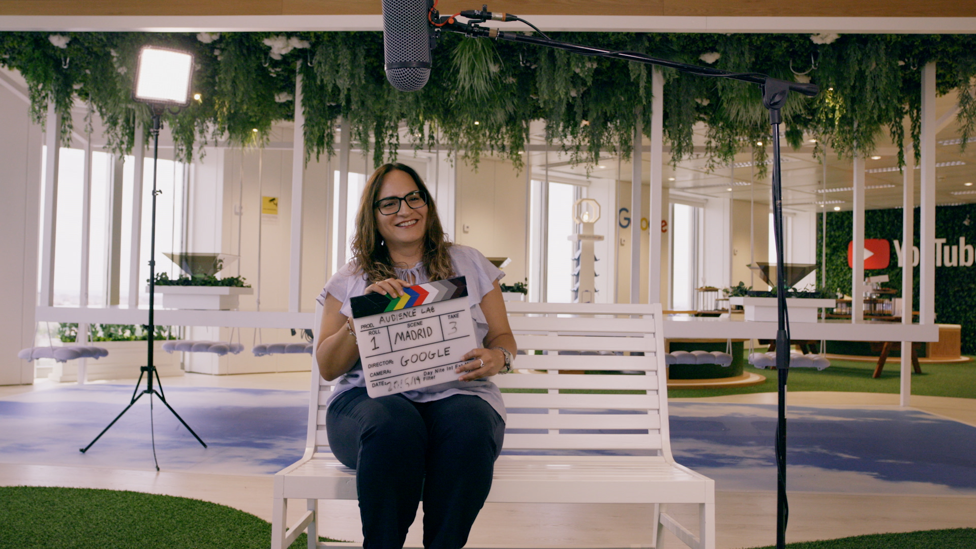 A participant in the video series holding a clapperboard on set