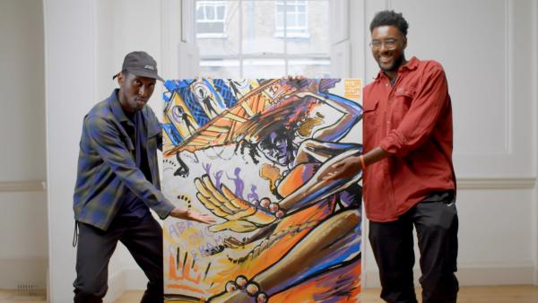 Samm Henshaw and WumZum standing either side of a colourful painting