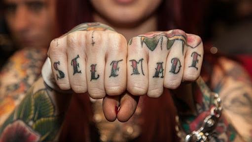 "SELF MADE" tattoo across a woman's knuckles 